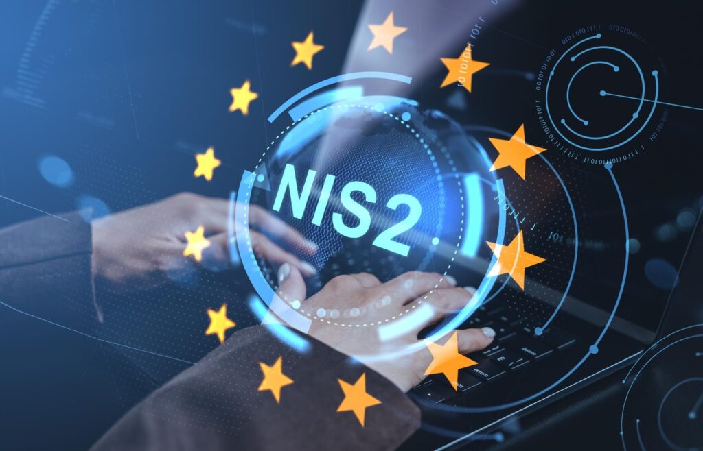 Symbolbild zur NIS2-Richtlinie: Digitale Sicherheitsgrafik mit der Aufschrift ‚NIS2‘, umgeben von EU-Sternen, über Händen an einer Tastatur.
