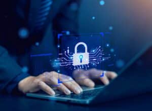 Hände tippen auf einer Laptop-Tastatur, darüber ein digitales Schloss-Symbol